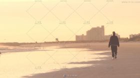 夕阳中海滩上行走的人物背影高清实拍视频素材